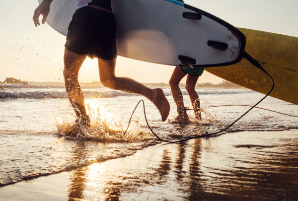 Surfers legs running into the waves. 