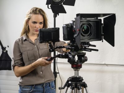 A woman operating a camera for a product shoot. 